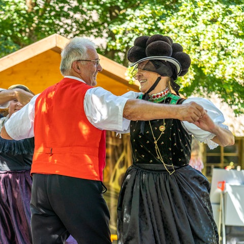 Eine Volkstanzgruppe tanzt in Schwarzwälder Tracht.